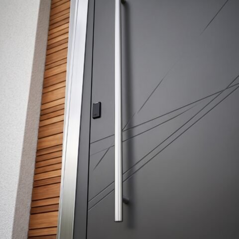 Modern matte gray Pivot Door Double Heighted Door with geometric detailing and glass sidelights by Tarkhan Door