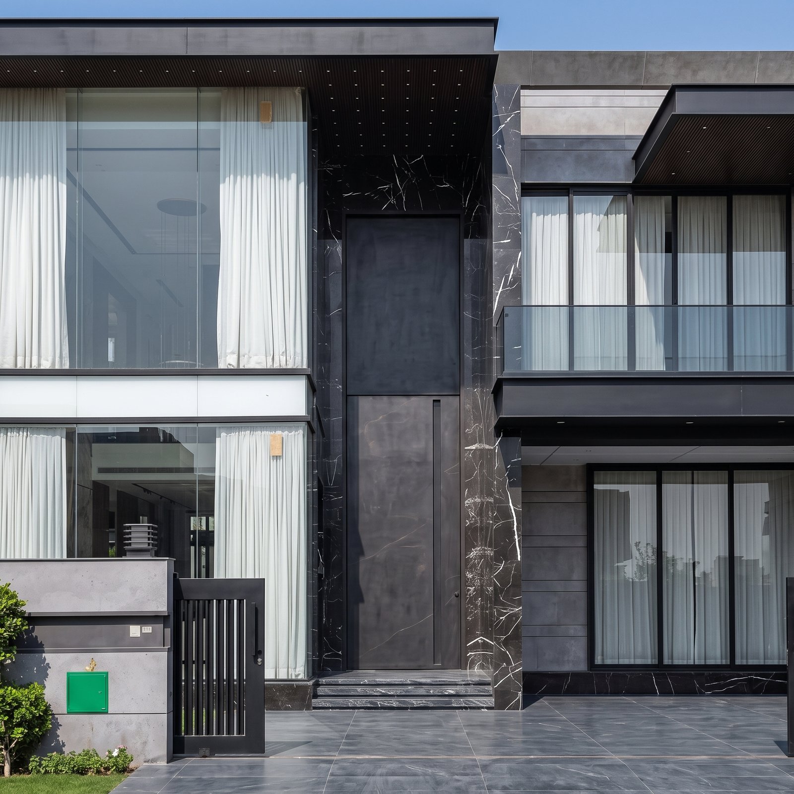 Tarkhan-Black-Marble-Series-Double-Heighted-Pivot-Door A massive matte black double heighted pivot door framed by black veined marble on a luxury modern residence by Tarkhan Door.
